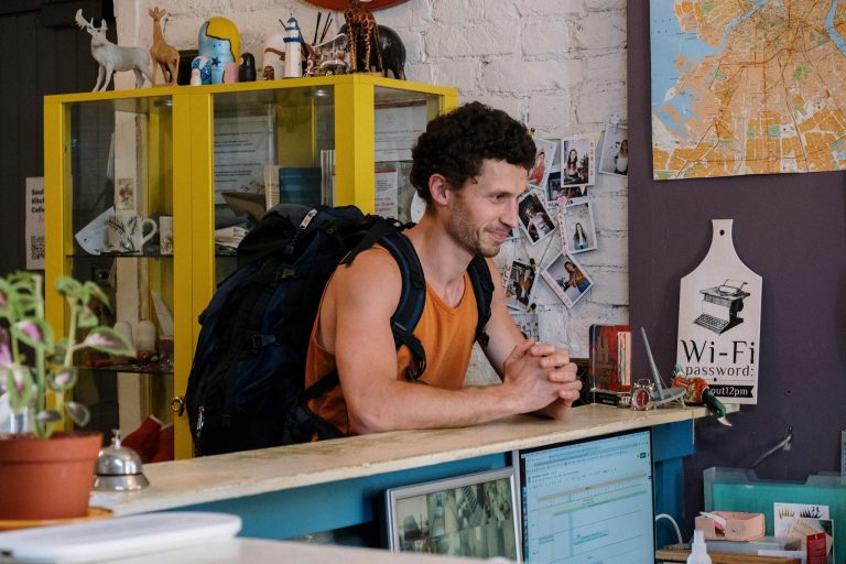 Man in Orange and Black Tank Top Sitting on Chair